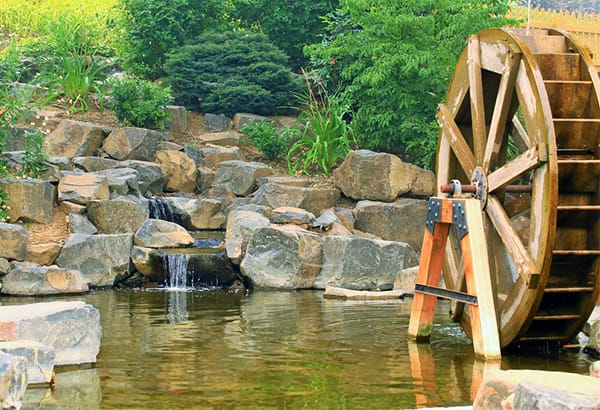 Wasserrad und kleiner Wasserlauf als anschauliches Modell fuer Wasser und Energie