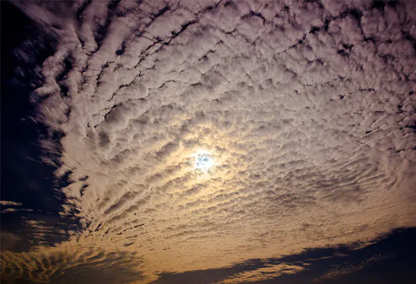Strukturierte Wolkendecke mit Sonne als Motiv fuer Wetterbeobachtung